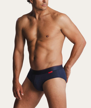 Man met donkerblauwe slip aan met rood Undiemeister logo op de tailleband