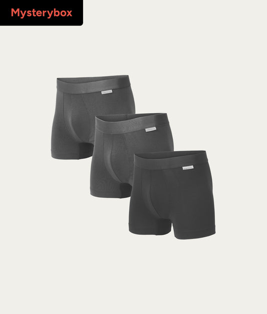 Drie zwarte heren boxershorts naast elkaar op een lichte achtergrond