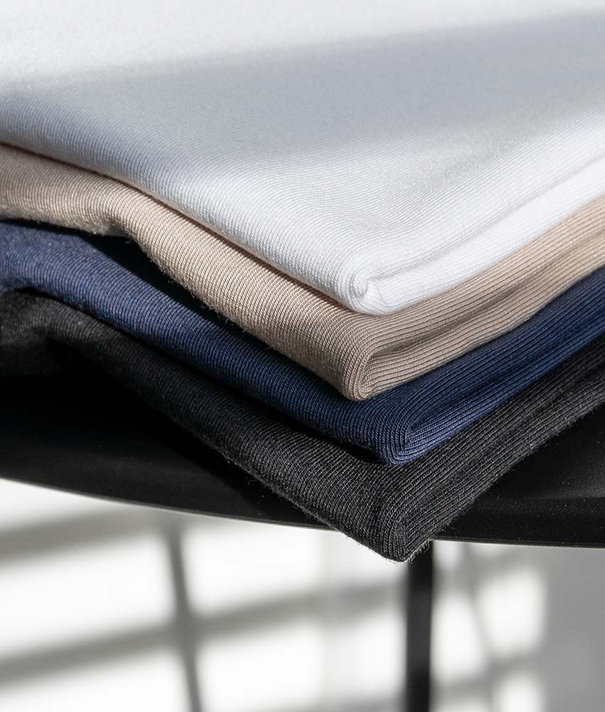 Stapel met opgevouwen polo shirts in de kleuren wit, beige, blauw en grijs